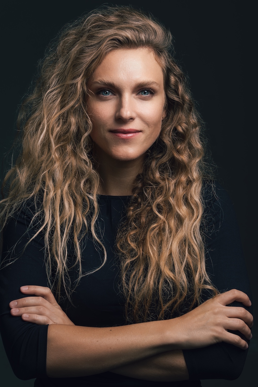 Daria Driuchenko looks into the camera with her arms crossed.